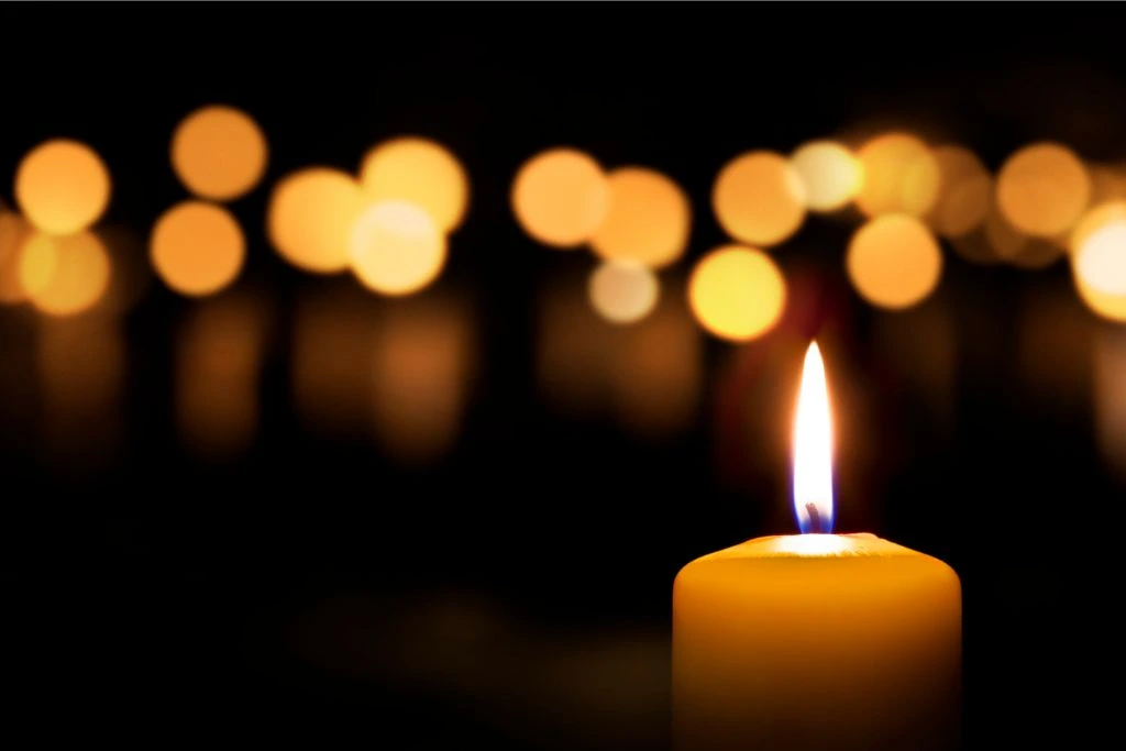 A lighted candle on a dark background