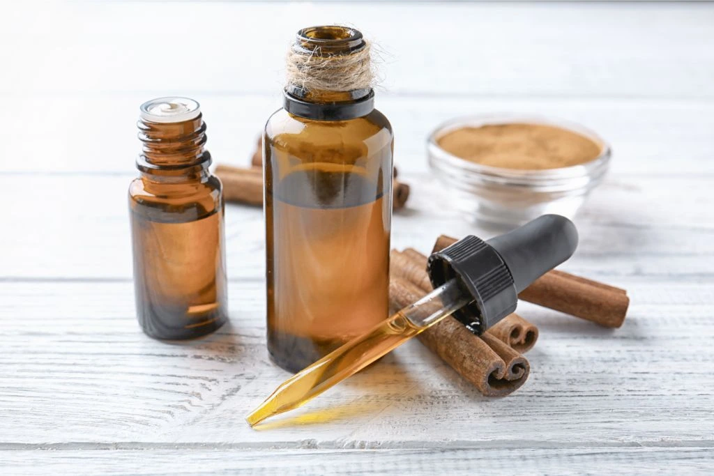 cinnamon oil bottle with dropper and cinnamon stick