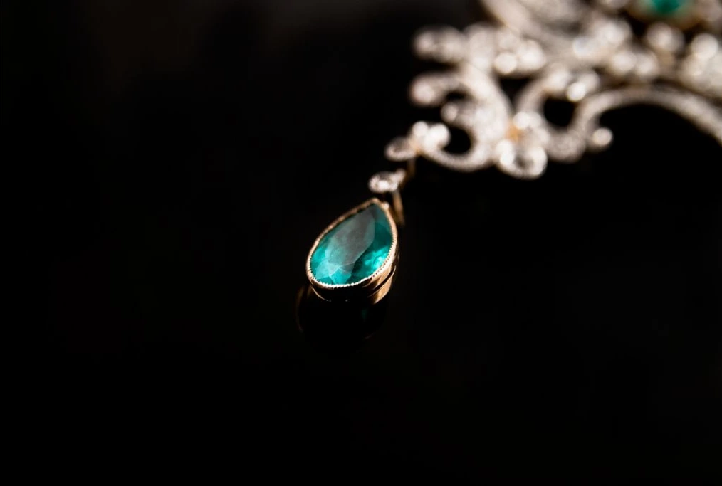 emerald necklace placed on top of a black table