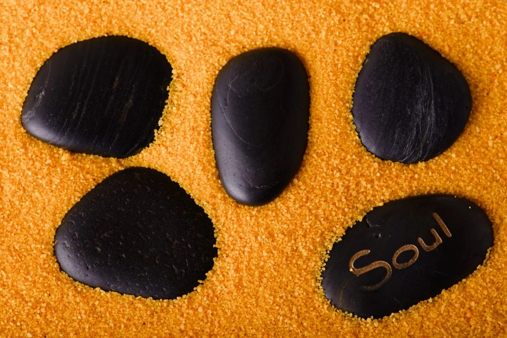 several polished lava stones situated in yellow sand