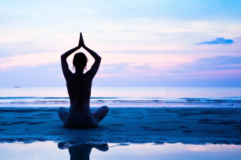 A woman sitting on the sand at the beach