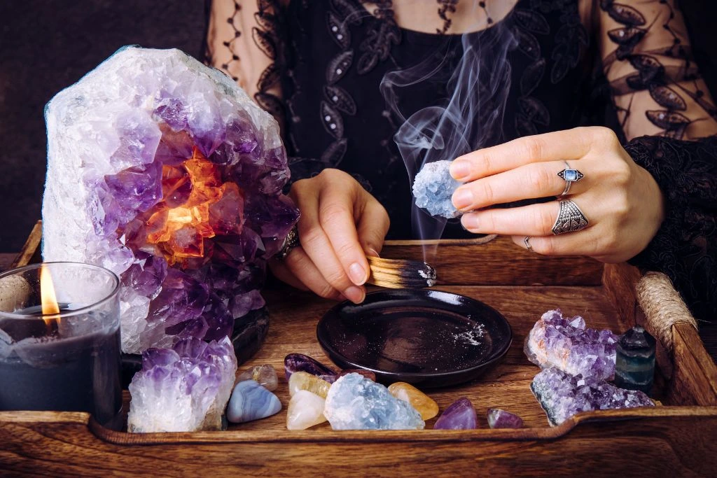 woman cleansing crystals with palo santo