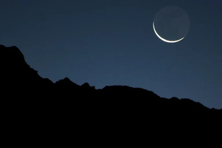 new moon on a dark mountain background