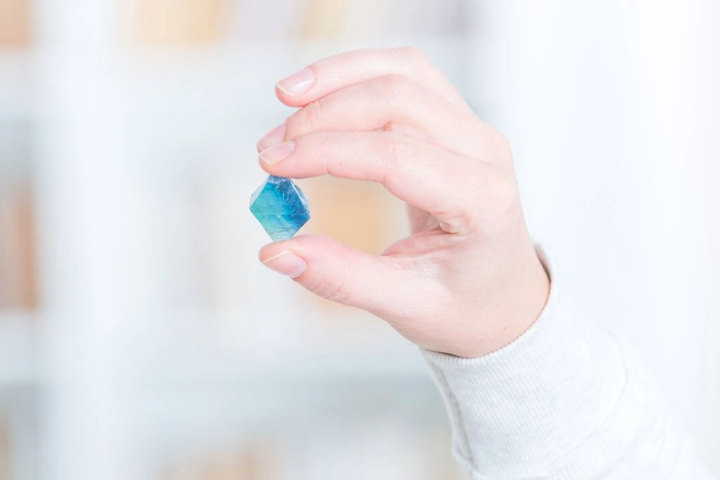 a hand holding up fluorite gemstone