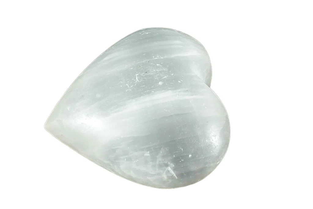 polished heart shaped Selenite on a white background