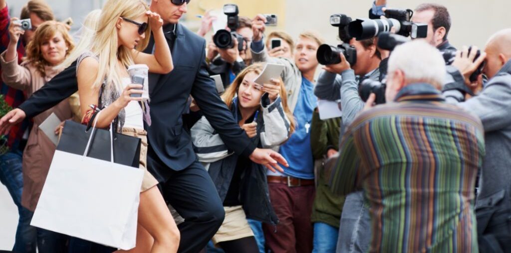 A woman being followed by group of paparazzies
