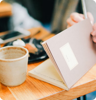 A person opening a notebook on the table