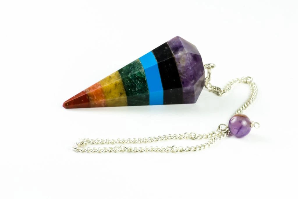 7 Chakra Crystal Pendulum on a white background