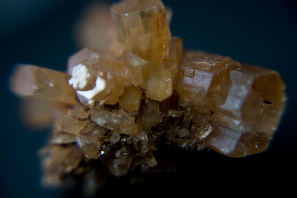 An Aragonite crystal cluster on a blue background