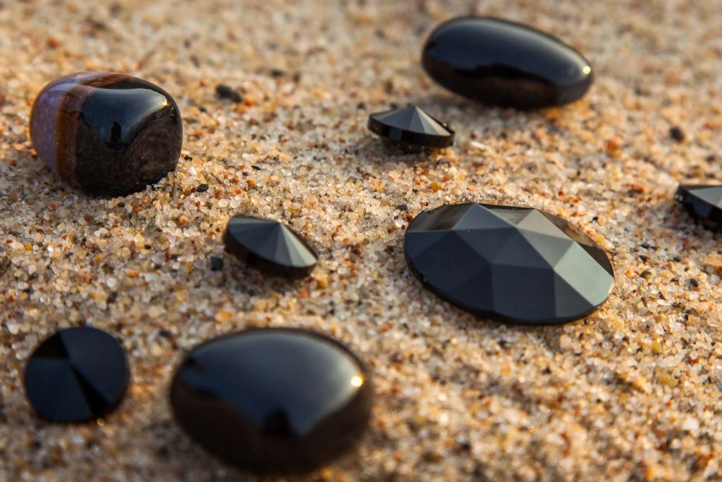 Black onyx crystal placed on a beach sand