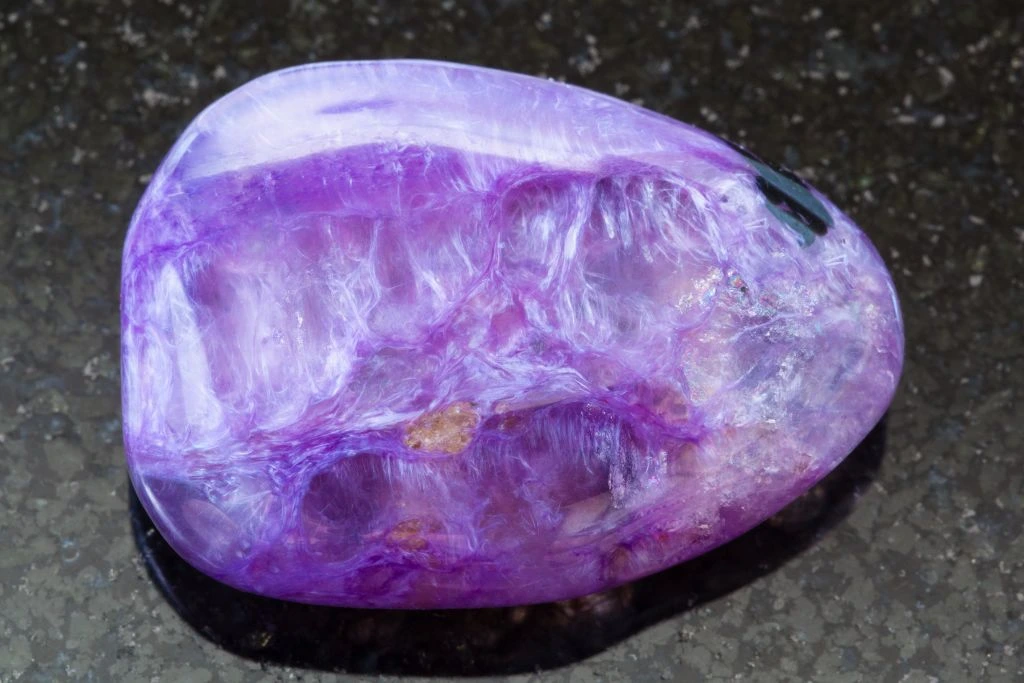 A Charoite on a black granite