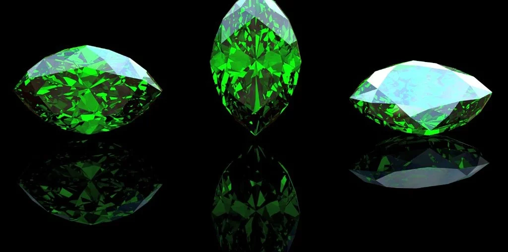 three crystals either identified as emerald or peridot placed right next to each other