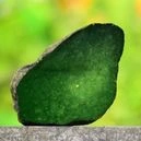 A jade crystal cut in half on a pavement