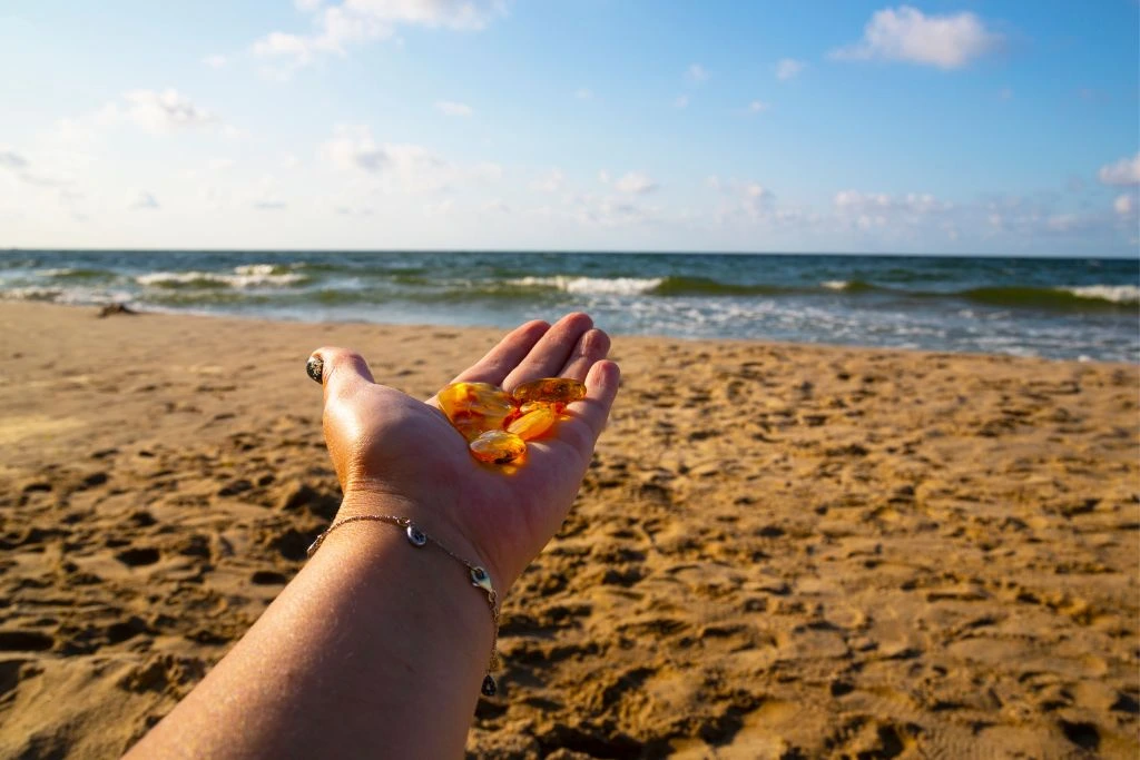 Sunstone crystals placed on hand in a beach setting