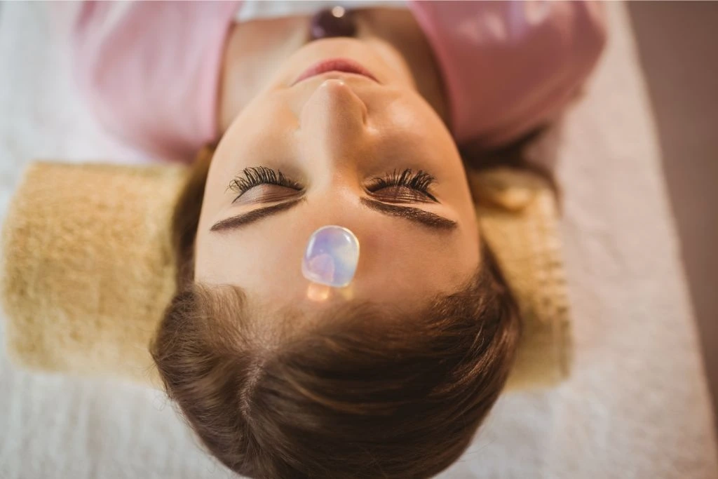 A polished crystal on a young lady's forehead