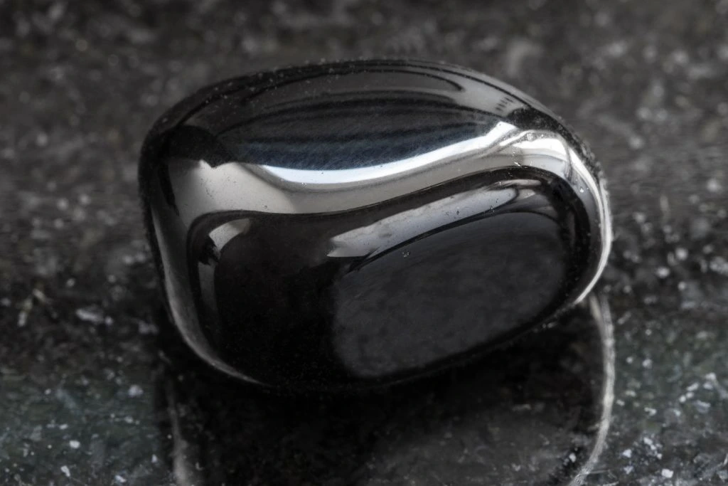 A black onyx crystal on a black granite