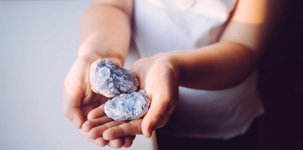a woman holding celetite on the palm of her hands