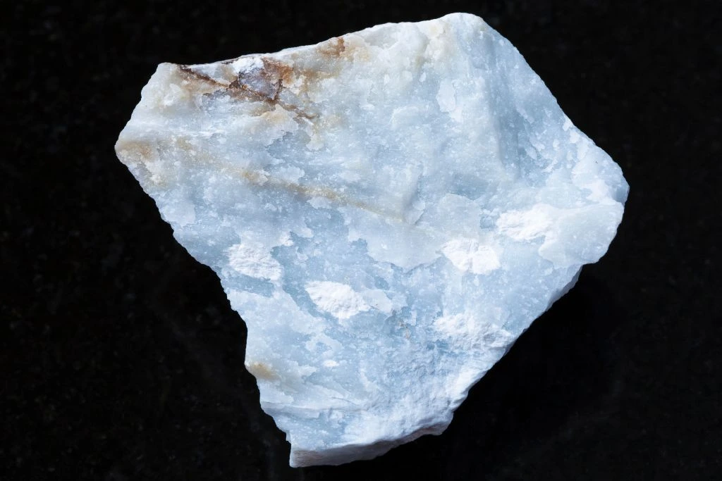 a raw angelite stone on a black background