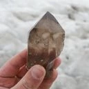 hand holding a smoky quartz crystal