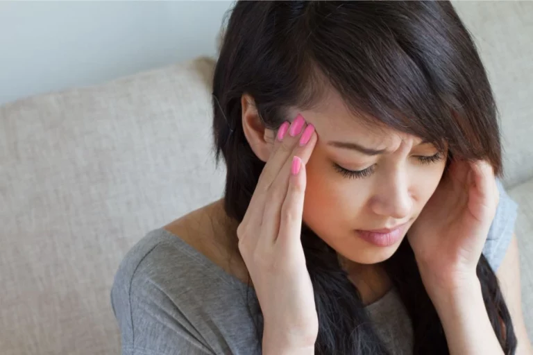 a woman experiencing headache and crystals that can help with vertigo and nausea