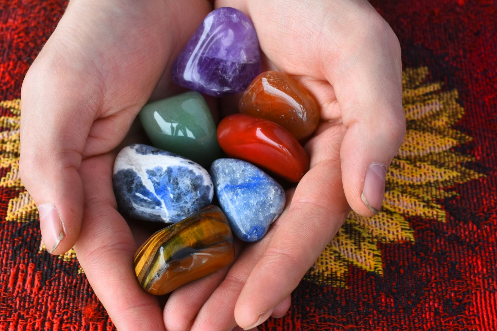 7 chakra crystals on model's hand