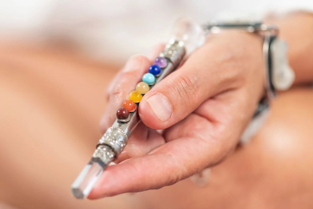 A person holding a 7 chakra wand