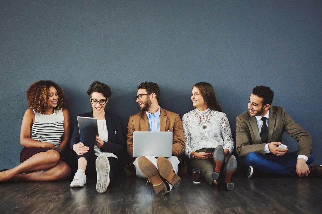 A group of people sitting in the floor and smilling