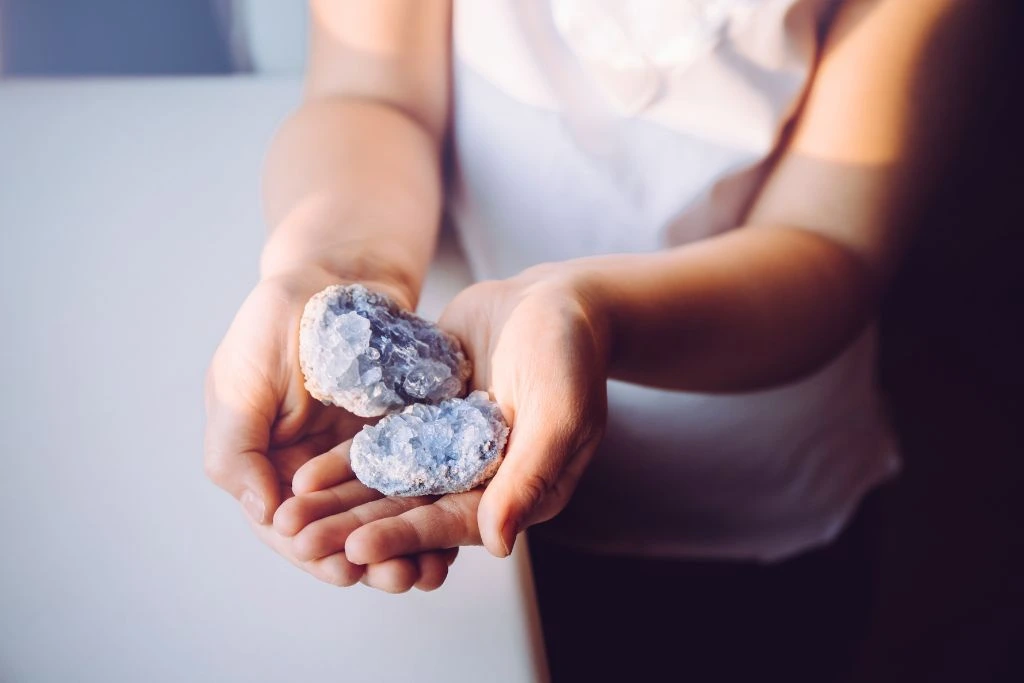 A person holding a crystal cluster