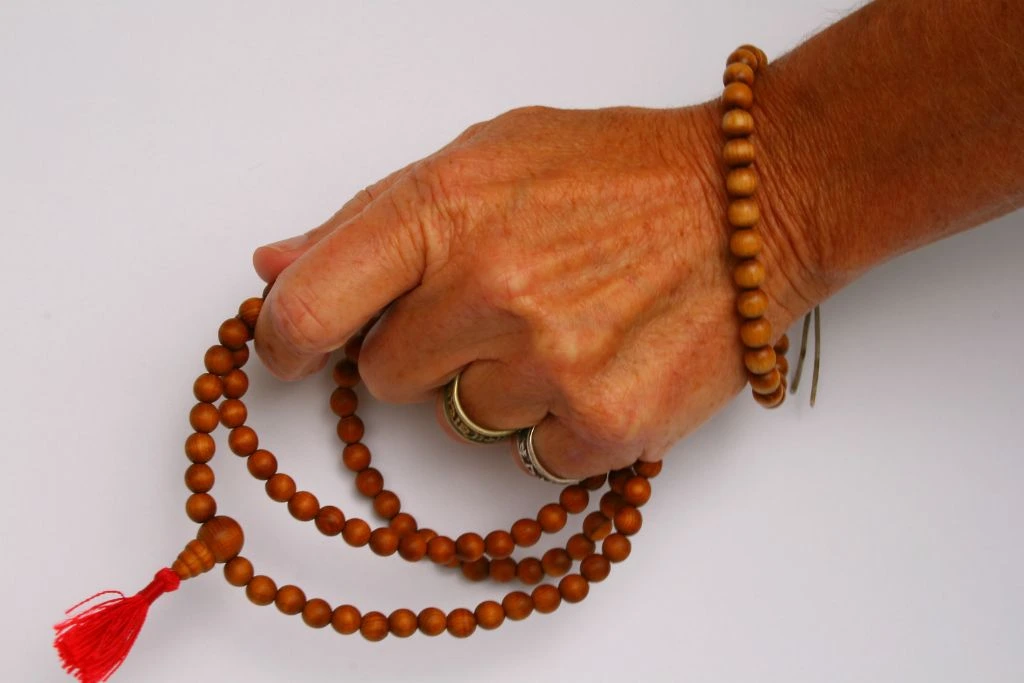 A person holding a Buddhist prayer beads