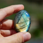 A person holding a labradorite crystal