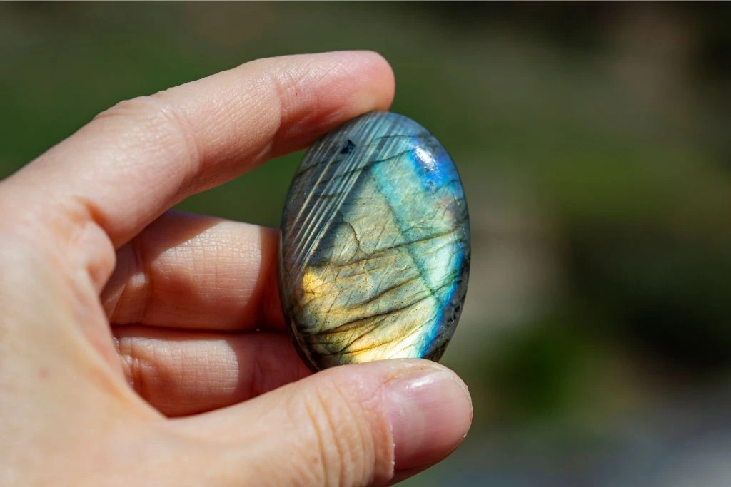 A person holding a labradorite crystal