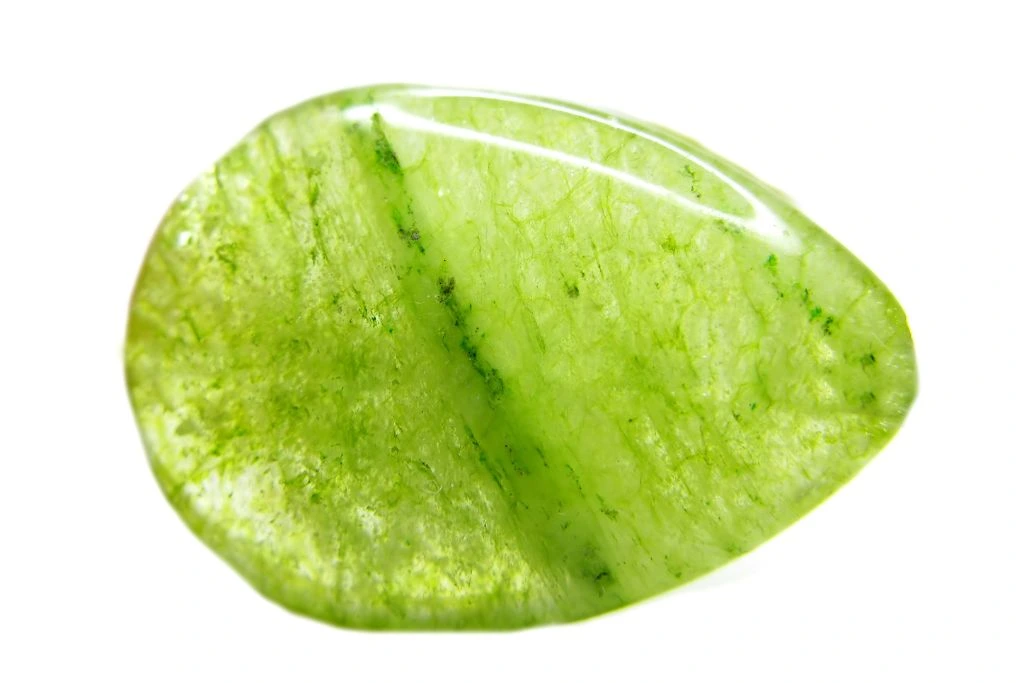 A polished peridot green crystal on white background