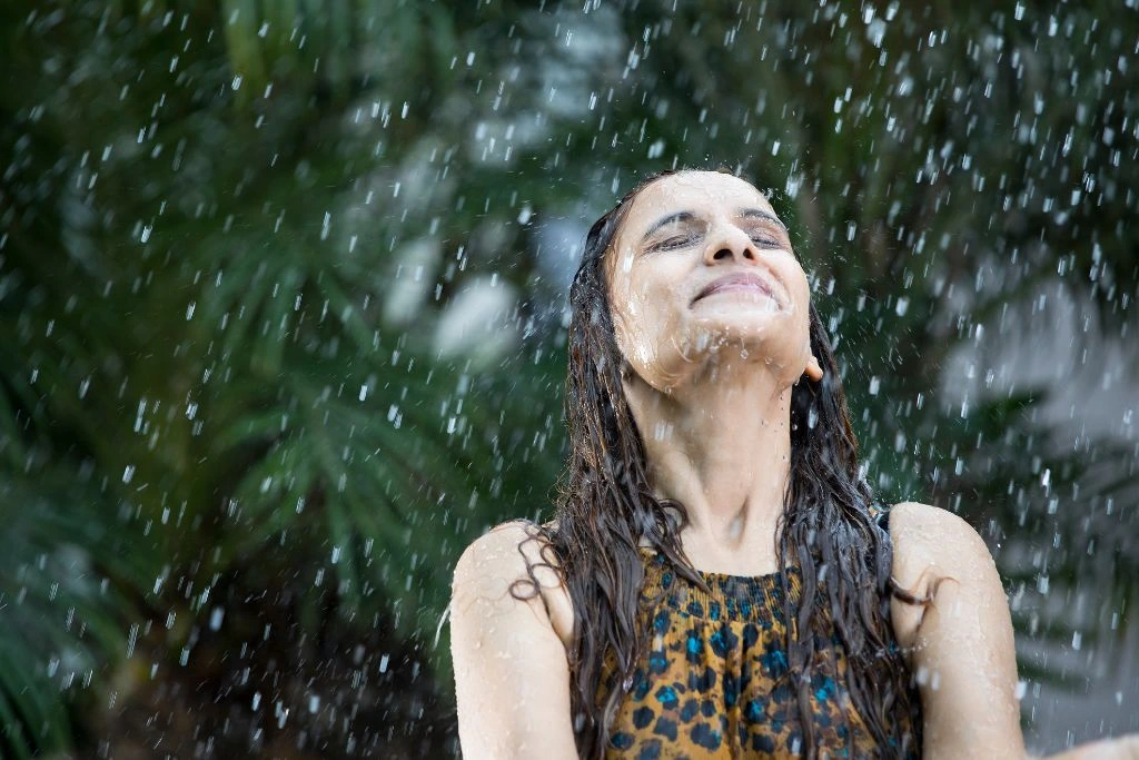 A woman enjoying the rain outside
