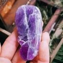 A person holding an amethyst crystal