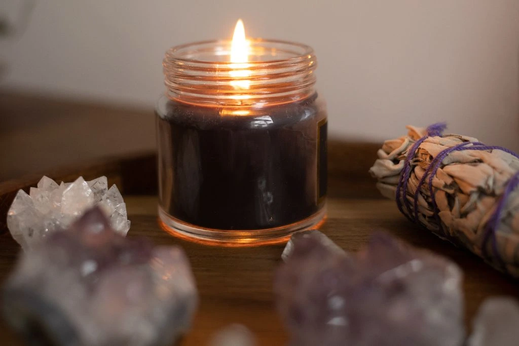 A Burning candle and a sage stick on the table