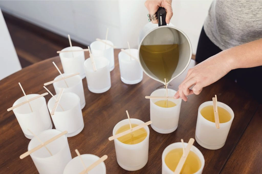 woman pouring melted wax into silicone molds