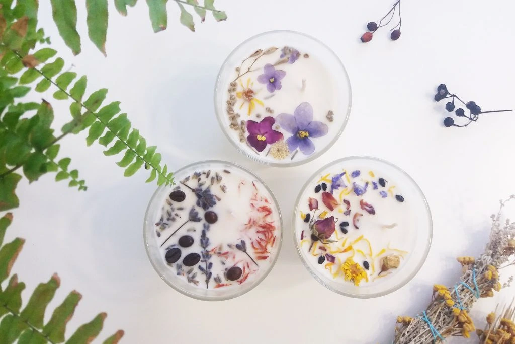 flat lay image of crystals candles with dried flowers and leaves
