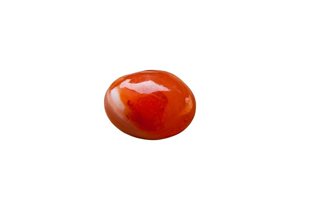 Carnelian palm stone crystal on a white background