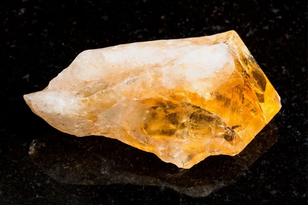 Chunk of Citrine Crystal placed on a black surface table