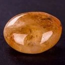 Polished Citrine crystal placed on a black surface table