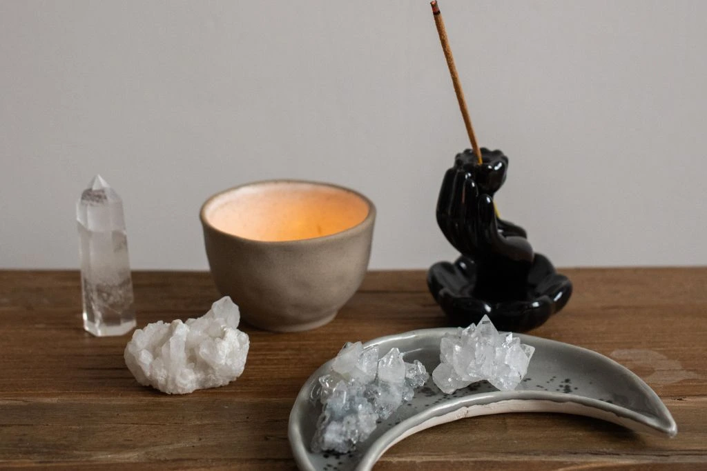 A table with crystal cluster, incense and candle
