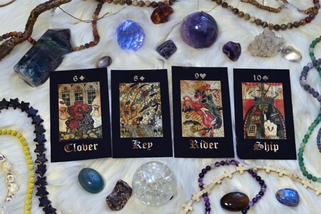 Tarot cards with different kinds of crystals and magic objects on a fur cloth