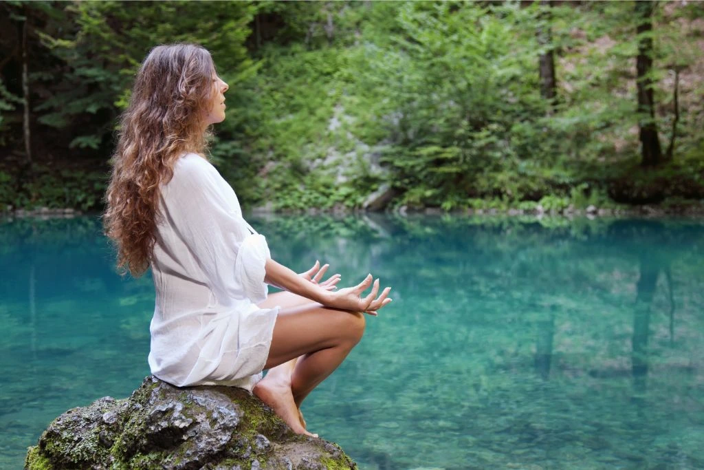 a Lady meditating at the lake