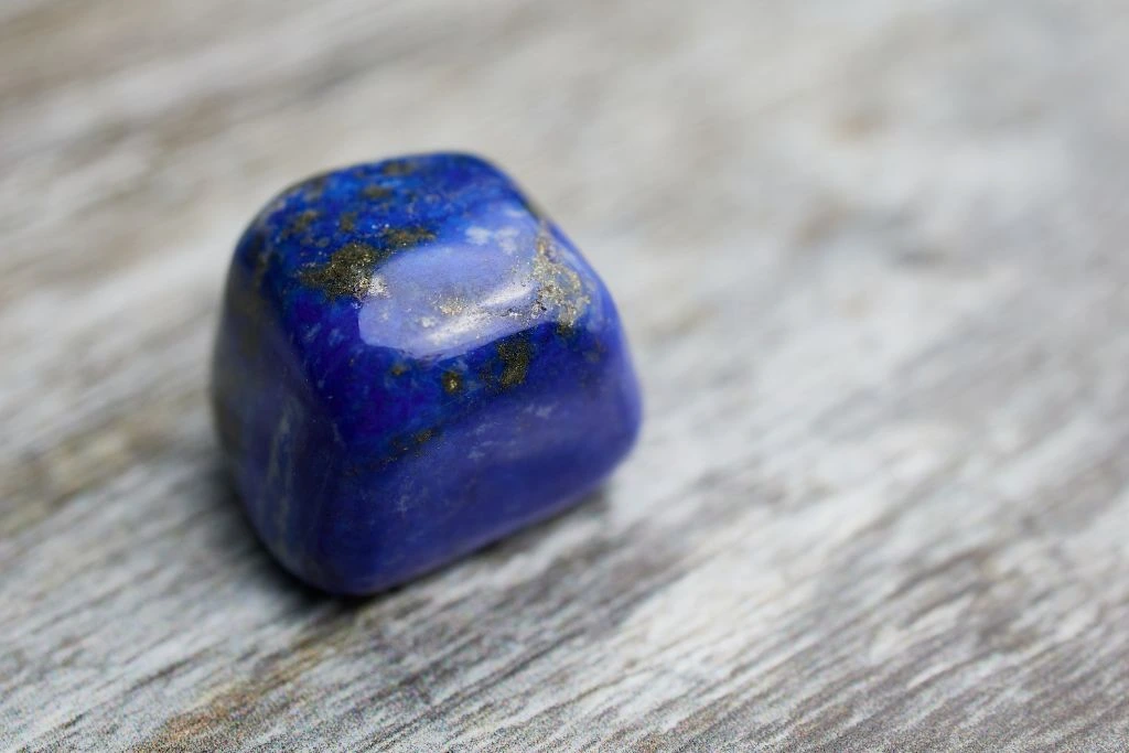A lapis lazuli crystal on a wooden table