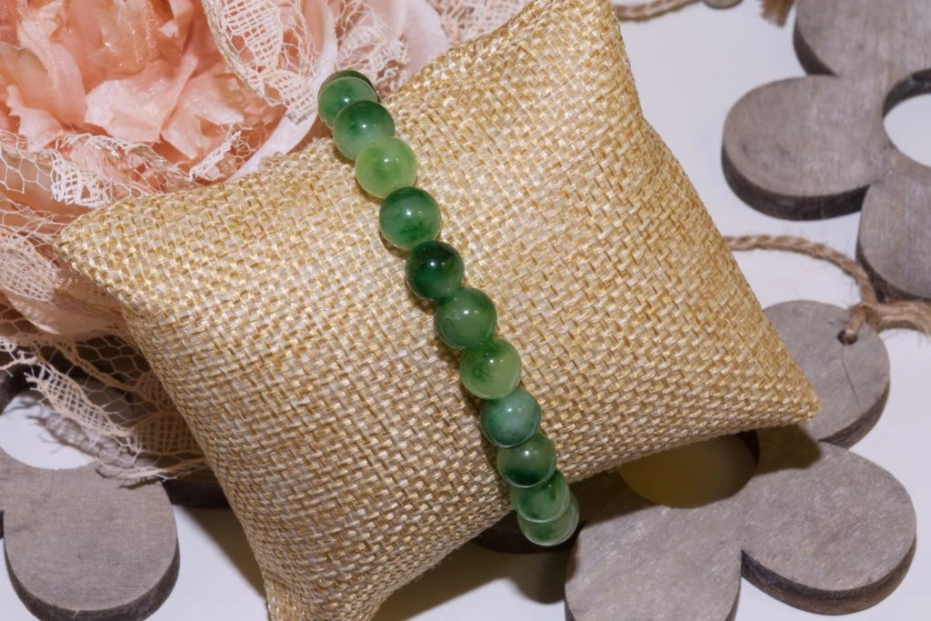 A moss agate bracelet on the small jute pillow