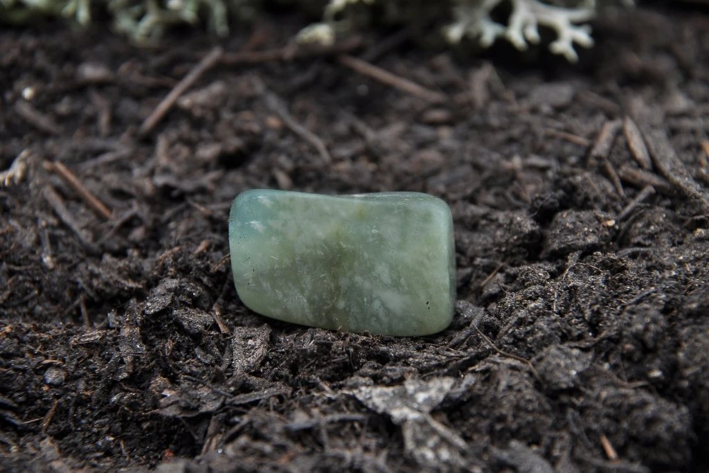 Moss agate crystal on the soil