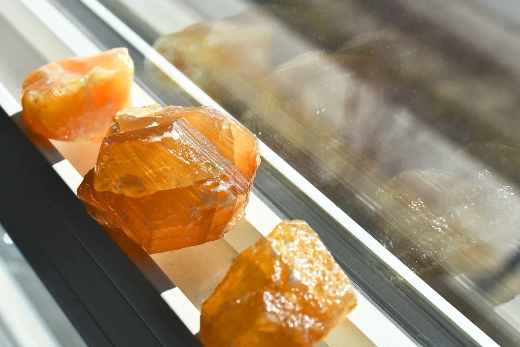 An orange calcite crystals on a window sill