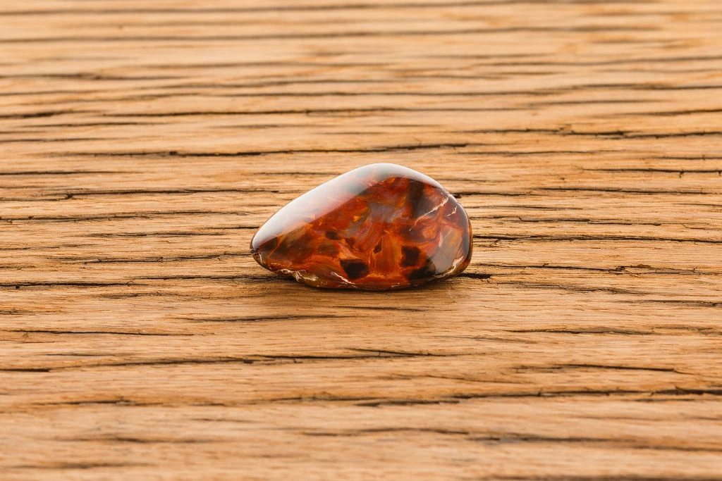 a polished Pietersite crystal on a wooden surface