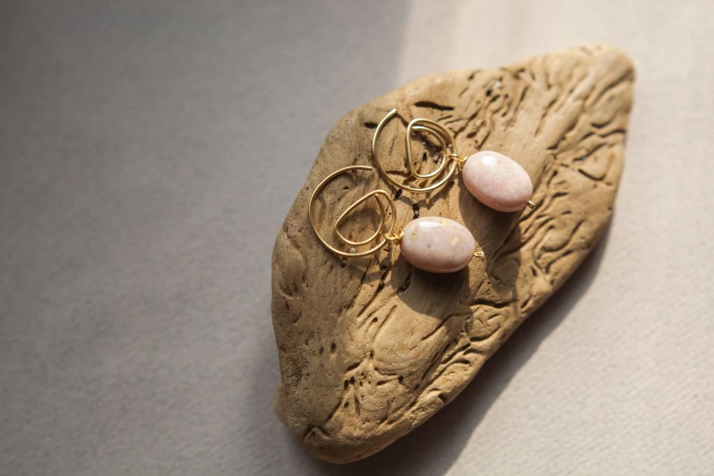 Pink opal earrings on a wood