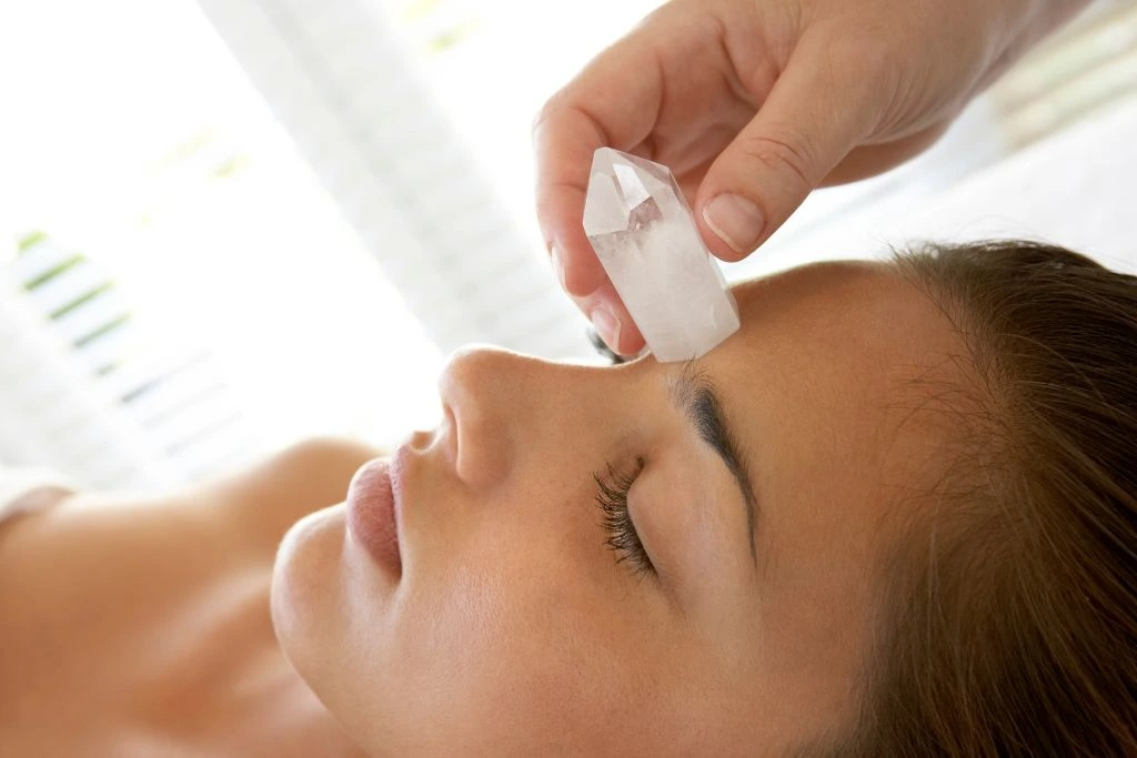 A clear quartz on a woman's forehead